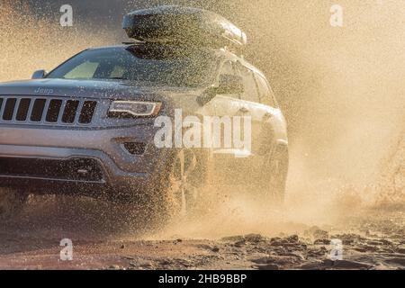 Jeep fährt durch Pfütze, spritzt Wasser Stockfoto