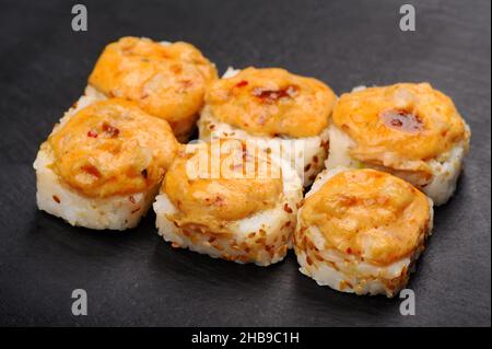 Gebackene heiße Käsebrötchen auf schwarzem Teller aus der Nähe Stockfoto