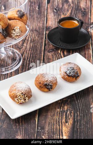 Bombolon oder Bomboloni ist ein italienisches gefülltes Donut- und Snackfutter. Deutsche Krapfen - Krapfen oder berliner - gefüllt mit Marmelade und Schokolade Stockfoto