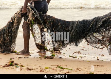 Fischer ziehen ihr Fangnetz aus dem Meer. Stockfoto