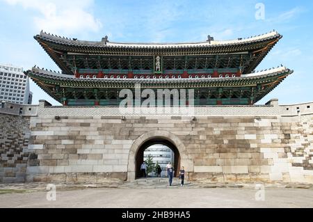 Namdaemun Gate oder Sungnyemun Gate zur blauen Stunde mit leichten Wegen von Fahrzeugen. Dieses historische Gebäude ist von hohen modernen Gebäuden umgeben. Stockfoto