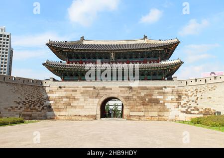 Namdaemun Gate oder Sungnyemun Gate zur blauen Stunde mit leichten Wegen von Fahrzeugen. Dieses historische Gebäude ist von hohen modernen Gebäuden umgeben. Stockfoto
