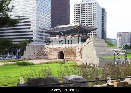 Namdaemun Gate oder Sungnyemun Gate zur blauen Stunde mit leichten Wegen von Fahrzeugen. Dieses historische Gebäude ist von hohen modernen Gebäuden umgeben. Stockfoto