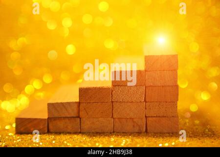 Podium für die Produktpräsentation. Minimalistische Treppe aus Holzwürfeln. Eine Szene mit geometrischen Formen. Auf einem glänzend gelben Hintergrund. Hochwertige Fotos Stockfoto