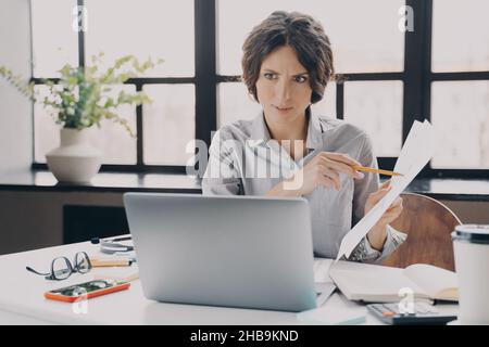 Seriöse, fokussierte italienische Geschäftsfrau, die im Büro Videoanruf auf einem Laptop macht Stockfoto