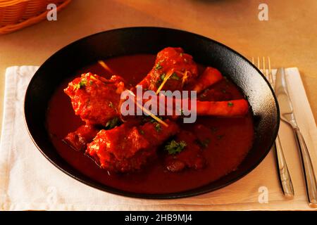 Langsam gekochtes indisches Lamm oder Hammelschenkelcury, auch bekannt als Nalli-rogan josh auf dem Esstisch Stockfoto