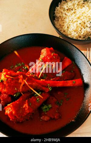 indisches Lamm- oder Hammelschenkelcury, auch bekannt als Nalli-rogan josh auf dem Esstisch Stockfoto