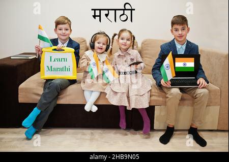 Vier Kinder zeigen Inschrift lernen marathi. Fremdsprachenlernkonzept. Indische Flaggen. Stockfoto
