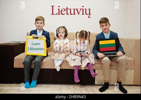 Vier Kinder zeigen die Inschrift litauisch lernen. Fremdsprachenlernkonzept. Stockfoto
