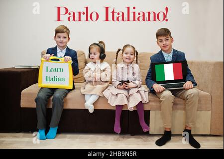 Vier Kinder zeigen die Inschrift Italienisch lernen. Fremdsprachenlernkonzept. Parlo Italiano! Stockfoto