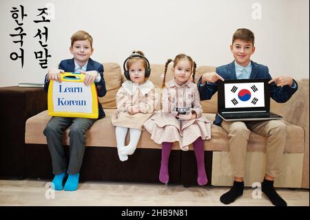 Vier Kinder zeigen die Inschrift koreanisch lernen. Fremdsprachenlernkonzept. Stockfoto