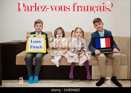 Vier Kinder zeigen die Inschrift Französisch lernen. Fremdsprachenlernkonzept. Parlez vous francais? Stockfoto