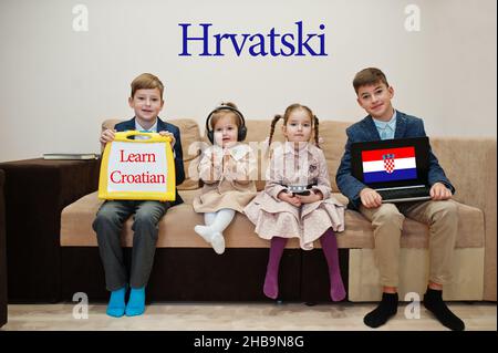 Vier Kinder zeigen die Inschrift kroatisch lernen. Fremdsprachenlernkonzept. Hrvatski. Stockfoto