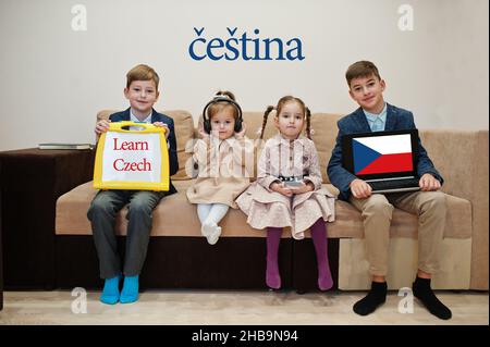 Vier Kinder zeigen die Inschrift Tschechisch lernen. Fremdsprachenlernkonzept. Cestina. Stockfoto