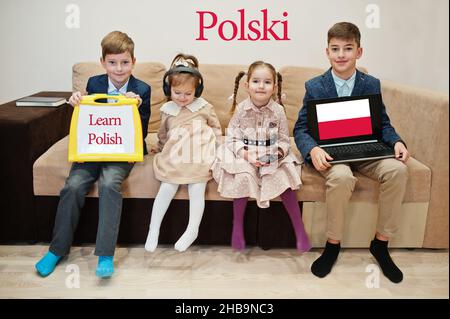 Vier Kinder zeigen Inschrift lernen Polnisch. Fremdsprachenlernkonzept. Polski. Stockfoto