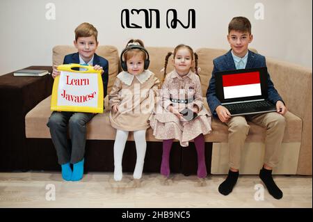 Vier Kinder zeigen die Inschrift javanesisch lernen. Fremdsprachenlernkonzept. Stockfoto