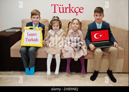 Vier Kinder zeigen die Inschrift Türkisch lernen. Fremdsprachenlernkonzept. Turkce. Stockfoto