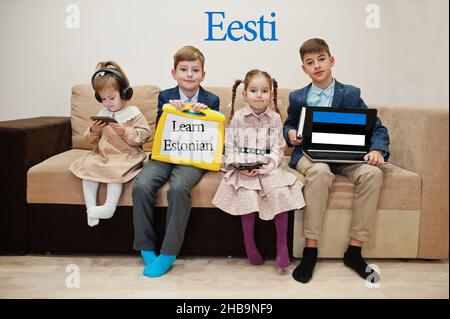 Vier Kinder zeigen die Inschrift estnisch lernen. Fremdsprachenlernkonzept. Eesti. Stockfoto