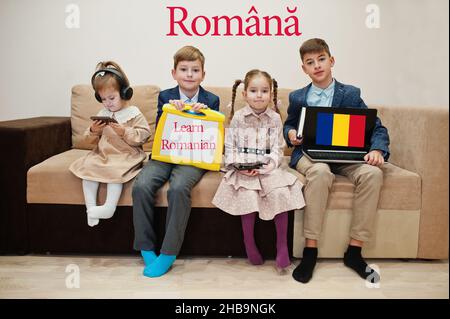 Vier Kinder zeigen die Inschrift rumänisch lernen. Fremdsprachenlernkonzept. Romana. Stockfoto