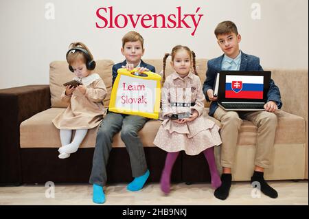 Vier Kinder zeigen die Inschrift slowakisch lernen. Fremdsprachenlernkonzept. Slovensky. Stockfoto