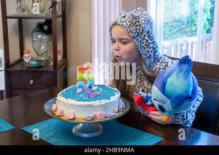 Lynwood, Washington, USA. Lily bläst an ihrem fünften Geburtstag ihre Kerzen aus Stockfoto