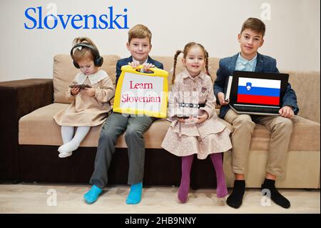 Vier Kinder zeigen die Inschrift slowenisch lernen. Fremdsprachenlernkonzept. Slovenski. Stockfoto