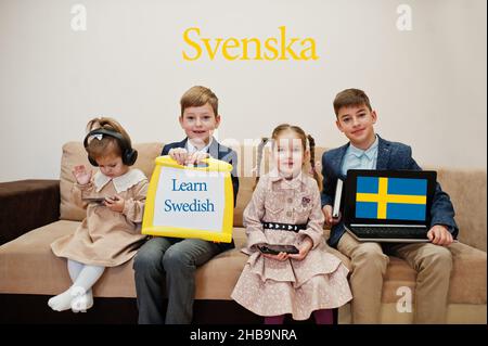 Vier Kinder zeigen die Inschrift Schwedisch lernen. Fremdsprachenlernkonzept. Svenska. Stockfoto