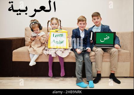 Vier Kinder zeigen die Inschrift Arabisch lernen. Fremdsprachenlernkonzept. Stockfoto
