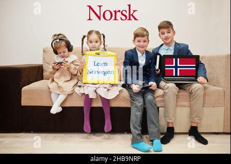 Vier Kinder zeigen die Inschrift norwegisch lernen. Fremdsprachenlernkonzept. Norsk. Stockfoto