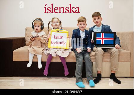 Vier Kinder zeigen die Inschrift isländisch lernen. Fremdsprachenlernkonzept. Islenska. Stockfoto