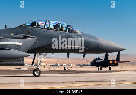 Ein F-15E Strike Eagle-Flugzeug, das 17th Waffenteam, Nellis Air Force Base, Nevada, zugewiesen wurde, hebt während einer weiteren F-15E wartet, während Weapons School Integration (WSINT) auf der Nellis Air Force Base, Nevada, am 30. November 2021. Der F-15E Strike Eagle ist ein Kämpfer mit zwei Rollen, der für die Durchführung von Luft-zu-Luft- und Luft-zu-Boden-Missionen entwickelt wurde. (USA Luftwaffe Foto von William Lewis) Stockfoto