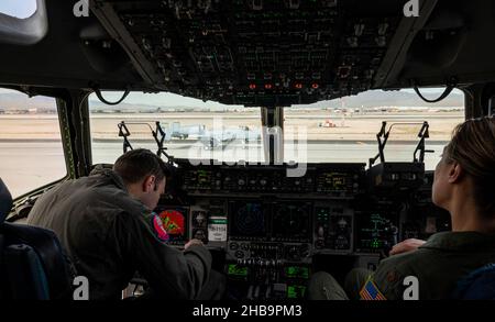 Zwei Mitglieder der Luftbesatzung, die dem 97th Air Mobility Wing, dem Luftwaffenstützpunkt Altus, Oklahoma, zugewiesen sind, sitzen im Cockpit eines C-17 Globemaster III, auf dem Luftwaffenstützpunkt Nellis, Nevada, während der Integrationsübung der US Air Force Weapons School auf dem Luftwaffenstützpunkt Nellis, Nevada, am 6. Dezember 2021. C-17 Flugzeuge und Mitglieder der Luftbesatzung von Altus AFB unterstützten WSINT 21-B. (USA Luftwaffe Foto von William Lewis) Stockfoto