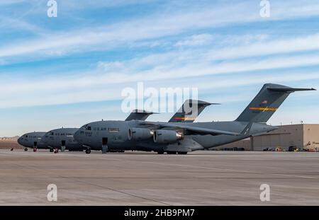 Drei C-17-Flugzeuge, die dem 97th Air Mobility Wing, dem Luftwaffenstützpunkt Altus, Oklahoma, zugewiesen wurden, parkten auf dem Luftwaffenstützpunkt Nellis, Nevada, während der Integrationsübung der US Air Force School auf dem Luftwaffenstützpunkt Nellis, Nevada, am 6. Dezember 2021. C-17 Flugzeuge und Mitglieder der Luftbesatzung von Altus AFB unterstützten WSINT 21-B. Stockfoto