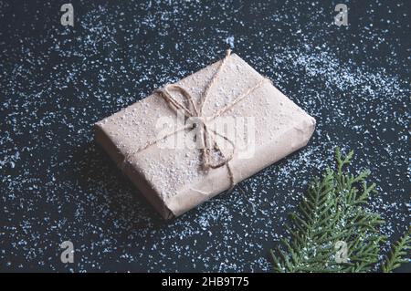 Vintage Geschenkbox mit Tannenzacken auf der Tafel. Geschenkbox mit Schnee auf dunklem Hintergrund. Stockfoto