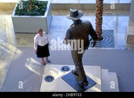 Frau bewundert die John Wayne Statue am Flughafen in Costa Mesa in Orange County, CA Stockfoto