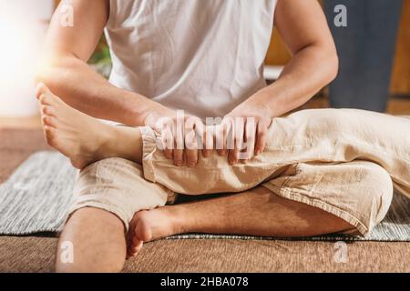 Thai-Massage zur Entspannung des Körpers. Masseur, der eine traditionelle Thai-Beinmassage gibt. Stockfoto