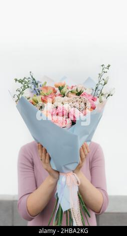 Bunten Strauß von verschiedenen frischen Blumen in der Hand von Floristen Frau. Rustikale Blume Hintergrund. Handwerk Blumenstrauß. Stockfoto