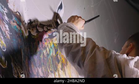 Künstler Designer zieht ein Adler an der Wand. Handwerker Dekorateur malt mit Acryl öl Farbe. Maler Maler gekleidet in Lack auftragen. Indoor. Stockfoto