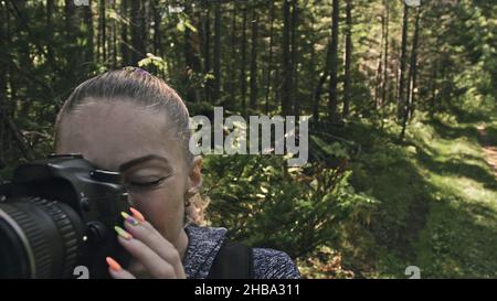 Traveler fotografieren malerischen Blick in den Wald. Eine kaukasische Frau schießen aus der Nähe betrachten. Mädchen nehmen Foto Video auf dslr spiegellosen Kamera. Stockfoto