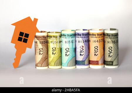 Indische Währungsscheine mit 2D Papiermodell Haus mit Schlüssel, Geld sparen für zukünftige Home Plan, Immobilien-Business-Konzept Stockfoto