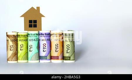 Indische Währungsscheine mit 2D Papiermodell zu Hause, sparen Sie Geld für zukünftige Home Plan, Home Loan Konzept Stockfoto