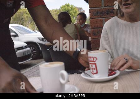 Kuchen und Kaffee an einem Samstagmorgen im Vorort Claremont von Kapstadt in Südafrikas „Mutterstadt“ während der globalen COVID-Pandemie Stockfoto