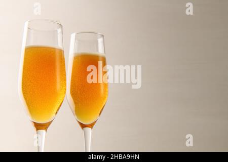 Zwei Gläser Champagner mit Blasen auf grauem Hintergrund. Neujahr und Weihnachten Hintergrund. Valentinstag Stockfoto