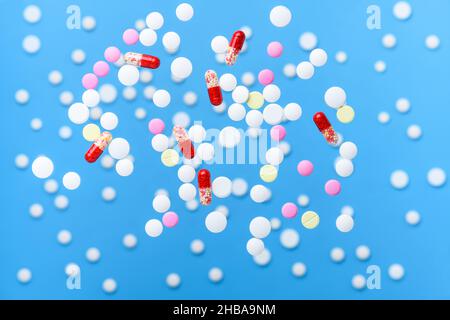 Fliegende Pillen und Levitationstabletten auf blauem Hintergrund. Medizin- und Gesundheitskonzept Stockfoto