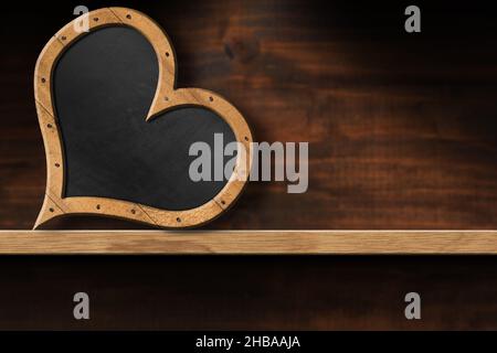 Leere Tafel mit Holzrahmen in Form eines Herzens, auf einem Holzregal mit Kopierraum. Stockfoto