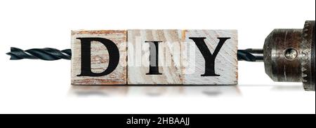 Nahaufnahme von DIY-Text (do it yourself), aus Holzblöcken und einer elektrischen Bohrmaschine mit schwarzer Spitze, isoliert auf weißem Hintergrund mit Kopierraum. Stockfoto