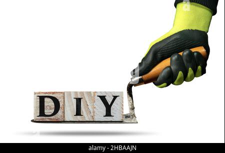 Arbeiter mit Arbeitsschutzhandschuhen, die eine schmutzige Kelle und den DIY-Text (do it yourself) halten, aus Holzblöcken. Isoliert auf weißem Hintergrund. Stockfoto