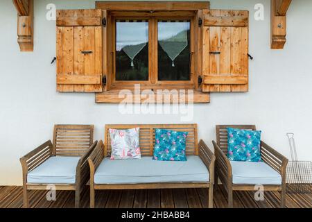 Schönes Holzfenster mit Fensterläden und einer Bank Stockfoto