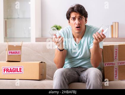 Der Mann öffnen zerbrechliches Paket aus dem Internet bestellt Stockfoto