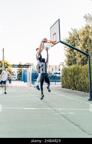 Großer Mann, der während eines freundlichen Basketballspiels auf einem Platz im Freien Punkte erzielte Stockfoto